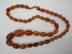 A strand of graduated oblong amber beads,