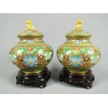 A pair of Chinese cloisonné covered vases of squat form, the body decorated with scrolling lotus,