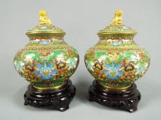 A pair of Chinese cloisonné covered vases of squat form, the body decorated with scrolling lotus,