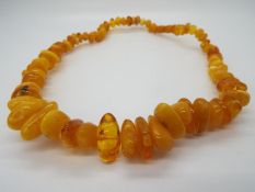A graduated amber bead necklace, largest bead 25 mm x 13 mm, smallest 10 mm x 7 mm,