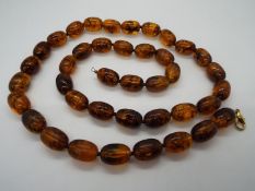 A string of 40 oblong amber beads, each approximately 20 mm x 14 mm,