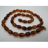 A string of 40 oblong amber beads, each approximately 20 mm x 14 mm,