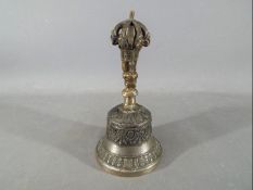 A Chinese Tibetan bronze ceremonial bell, with a gilt vajra shaped handle,