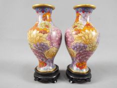 A small pair of Chinese cloisonné vases decorated with chrysanthemum, ruyi head band to the rim,