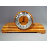 An Art Deco styled mahogany case mantel clock, the case with inlay and carved decoration,