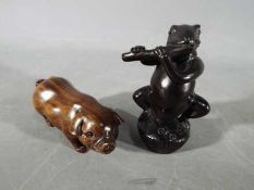 A vintage Japanese dark wood Netsuke depicting a frog type creature possibly playing a flute,