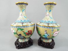 A pair of Chinese cloisonné vases decorated with flowers, birds and insects on an ivory ground,