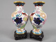 A small pair of Chinese cloisonné vases with floral decoration on a white ground,