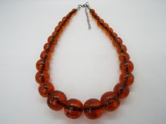 A graduated amber bead necklace of 30 beads, largest approximately 24 mm x 22 mm,