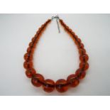 A graduated amber bead necklace of 30 beads, largest approximately 24 mm x 22 mm,