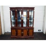 A large Chinese display cabinet with carved walnut panels, brass detailing with two keys,