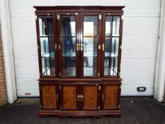 A large Chinese display cabinet with carved walnut panels, brass detailing with two keys,