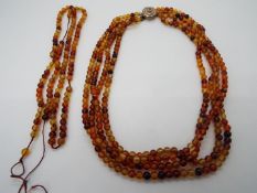 A multi strand necklace of small amber beads, approximately 5 mm (d), in need of re-stringing,