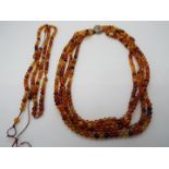 A multi strand necklace of small amber beads, approximately 5 mm (d), in need of re-stringing,