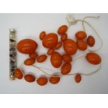 A graduated amber bead necklace, in need of re-stringing, largest bead 30 mm x 22 mm,