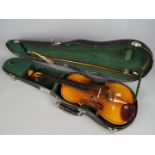 A 3/4 size violin with bow and chin support in hard protective case