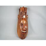 A large, tribal carving, wall hanging mask,