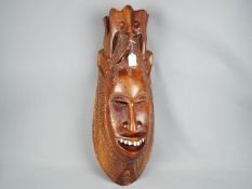 A large, tribal carving, wall hanging mask,