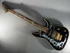 An Indie Dragon electric guitar finished in black with mother-of-pearl inlays, with soft carry case.