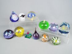 A collection of Caithness and similar paperweights.