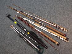 A collection of fishing rods and a net to include an NGT Beachcaster.