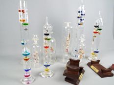 Five Galileo thermometers, largest approximately 43 cm (h) and four ships in bottles.