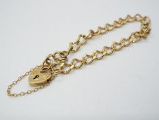 A 9ct yellow gold bracelet with padlock clasp and safety chain, approximately 7.66 grams all in.