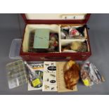 A wooden box containing a small collection of ready made fishing flies together with a large