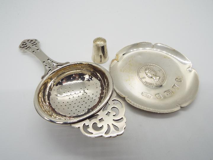 Three pieces of hallmarked silver to include a George V tea strainer, Birmingham assay 1932,