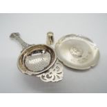 Three pieces of hallmarked silver to include a George V tea strainer, Birmingham assay 1932,