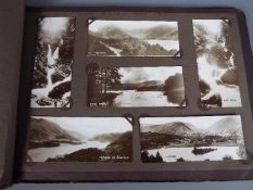 A vintage photograph album containing topographical images of the Lake District and a Popular Road