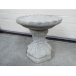 Garden Stoneware - a small garden bird bath with leaves on the plinth and a round top