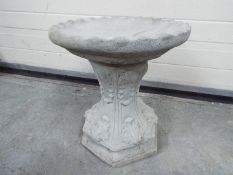 Garden Stoneware - a small garden bird bath with leaves on the plinth and a round top