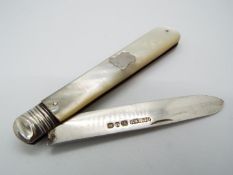 A Victorian silver and mother of pearl folding fruit knife, vacant cartouche to the handle,