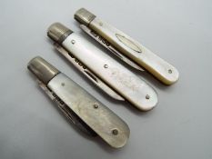 Three George V silver and mother of pearl folding fruit knives, all Sheffield assay,