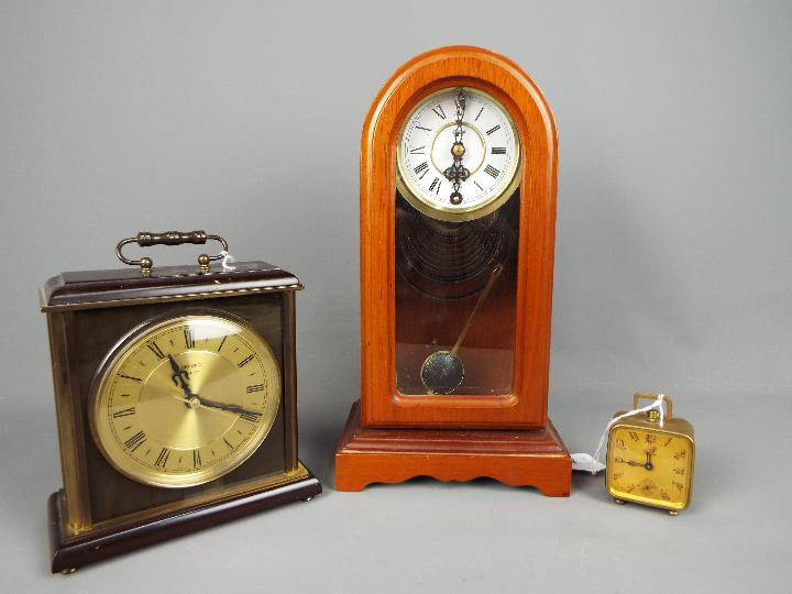 Three clocks to include a Brevete travel alarm clock, a Metamec mantel clock and similar.