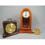 Three clocks to include a Brevete travel alarm clock, a Metamec mantel clock and similar.