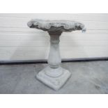 Garden Stoneware - A reconstituted stone bird bath with a baluster plinth and a octagonal scrolled