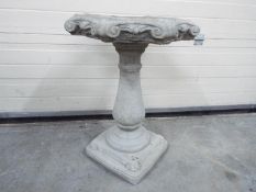 Garden Stoneware - A reconstituted stone bird bath with a baluster plinth and a octagonal scrolled