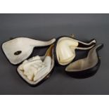 Two meerschaum pipes, one carved depicting a gentleman wearing a plumed hat,