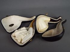 Two meerschaum pipes, one carved depicting a gentleman wearing a plumed hat,