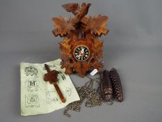 A German cuckoo clock with weights and pendulum.