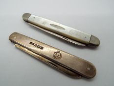 Two folding knives, the first a Victorian silver and mother of pearl example,