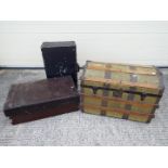 A vintage dome top shipping trunk, wooden chest and vintage suitcase.