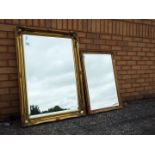 Two decorative gilt framed wall mirrors, largest approximately 76 cm x 106 cm.