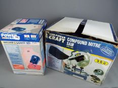 A boxed Powercraft compound mitre saw and a boxed welder's safety set.