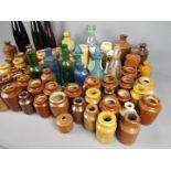 A collection of stoneware and glass bottles and pots, early to mid 20 th century,