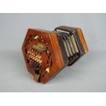 A Lachenal & Co 48 button concertina with hexagonal fretworked ends,
