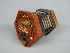 A Lachenal & Co 48 button concertina with hexagonal fretworked ends,