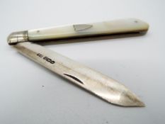 A George V silver and mother of pearl folding fruit knife, vacant cartouche to the handle,